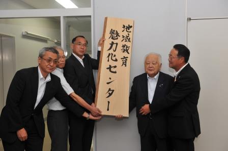 看板を掲げる学長と両町長など