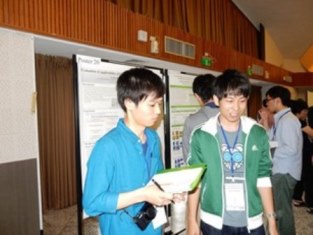 ポスター発表について討論する濱田さん（左）（総合理工学研究科）