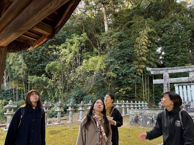 松平直政のお墓の入り口にある廟門を見る参加者と説明する語り部